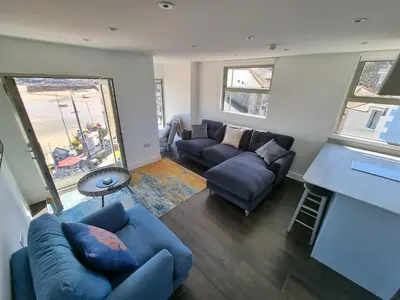 a living room with a couch and a table at Chy Mor Apartment 2 - Stunning sea views on the harbour in St Ives