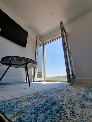 an empty living room with a sliding glass door at Chy Mor Apartment 2 - Stunning sea views on the harbour in St Ives