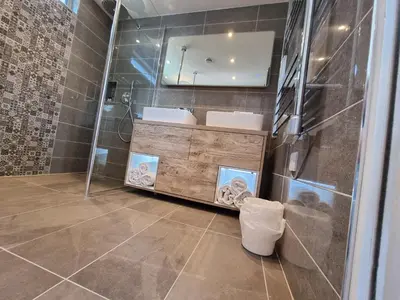 a bathroom with two sinks and a mirror at Chy Mor Apartment 2 - Stunning sea views on the harbour in St Ives
