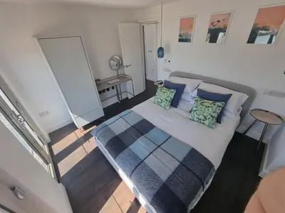 a bedroom with a large bed with blue pillows at Chy Mor Apartment 2 - Stunning sea views on the harbour in St Ives