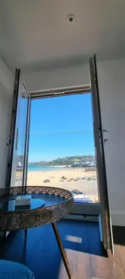 a room with a table and a view of the beach at Chy Mor Apartment 2 - Stunning sea views on the harbour in St Ives