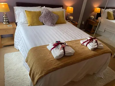 a bedroom with a large bed with towels on it at Headland View. Luxury. Harbour-Front. With Parking in Falmouth
