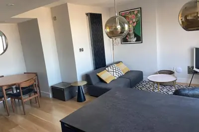 a living room with a couch and a table at Beachside apartment in the centre of town in Newquay