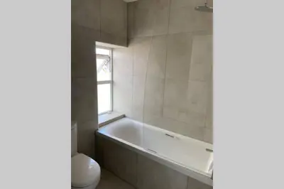 a bathroom with a tub and a toilet and a window at Beachside apartment in the centre of town in Newquay