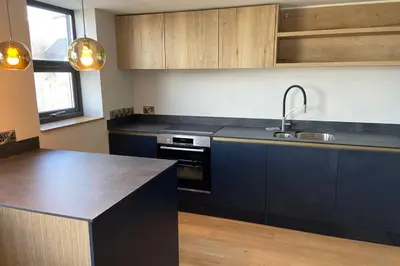 a kitchen with blue cabinets and a sink and a stove at Beachside apartment in the centre of town in Newquay