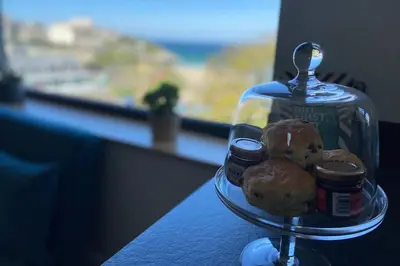 a glass plate with donuts and jams on a table at Beachside apartment in the centre of town in Newquay