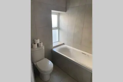 a bathroom with a toilet and a tub and a sink at Beachside apartment in the centre of town in Newquay
