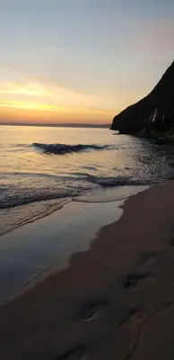 a beach with a sunset and the ocean at Stargazy Shepherds Hut in St Ives