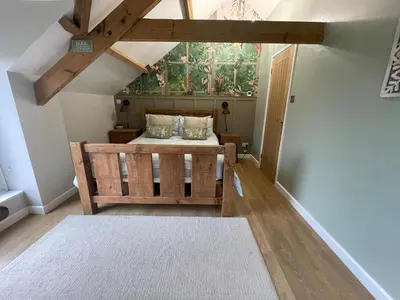 a bedroom with a bed and a window at The Barn at Well Cottage in Bude