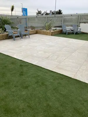 a patio with two chairs and a table and grass at Beautiful 3 bedroom apartment by the Sea in Newquay