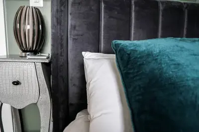 a couch with a blue pillow and a side table at Beautiful 3 bedroom apartment by the Sea in Newquay