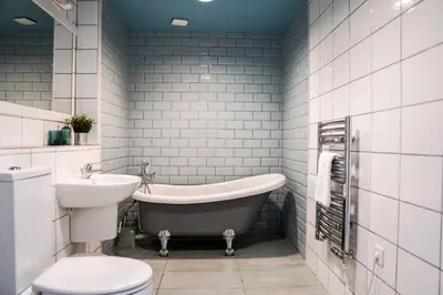 a bathroom with a tub and a toilet and a sink at Beautiful 3 bedroom apartment by the Sea in Newquay