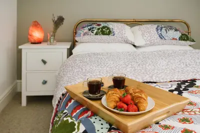 a tray of croissants and fruit on a bed at Finest Retreats - Atlantic Hideaway in Newquay