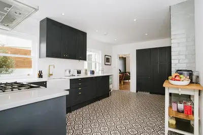 a kitchen with black cabinets and a bowl of fruit on the counter at Finest Retreats - Atlantic Hideaway in Newquay