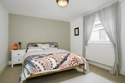 a white bedroom with a bed and a window at Finest Retreats - Atlantic Hideaway in Newquay