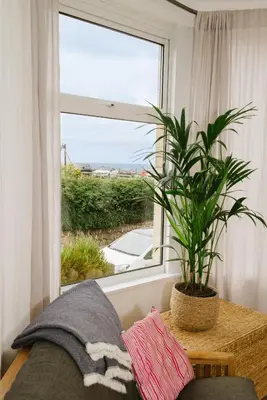 a plant sitting on a table next to a window at Finest Retreats - Atlantic Hideaway in Newquay