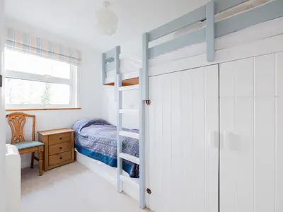 a bedroom with a bunk bed and a desk at Slipway 21 in Padstow
