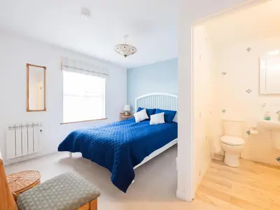 a bedroom with a blue bed and a toilet at Slipway 21 in Padstow