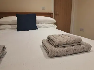 a bed with two towels sitting on top of it at Seven Bays Stays in St Merryn