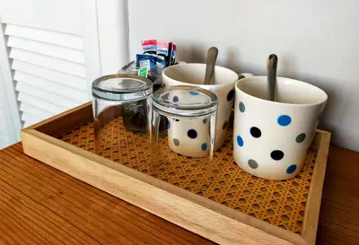 a wooden tray with three mugs and glasses on a table at Seven Bays Stays in St Merryn