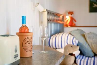a bottle of wine and a glass on a table at Mount View Overnight Accommodation in Penzance
