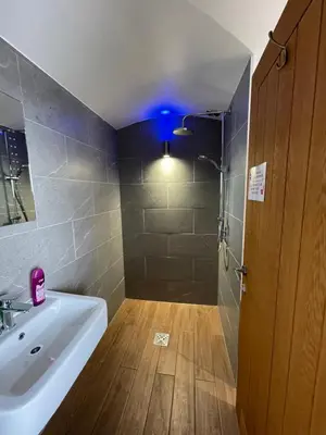 a bathroom with a sink and a shower with a blue light at Mount View Overnight Accommodation in Penzance