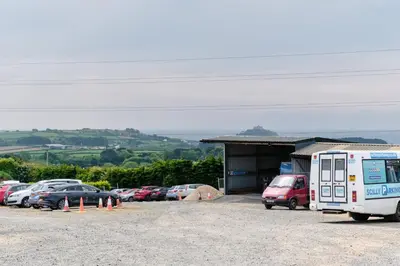 a parking lot with cars parked in front of a building at Mount View Overnight Accommodation in Penzance