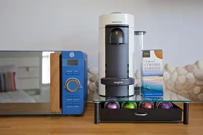 a coffee machine next to a box of ornaments at Pebbles - A relaxing King Studio in St Ives