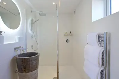a bathroom with a shower and a sink at Pebbles - A relaxing King Studio in St Ives