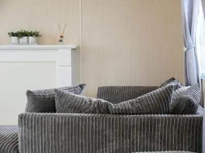 a couch with pillows in a living room at Stowaway St Merryn in St Merryn