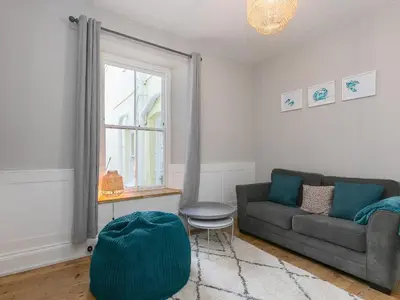 a living room with a couch and a window at Trengoff in St Ives
