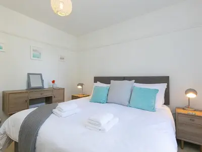 a bedroom with a large white bed with blue pillows at Trengoff in St Ives