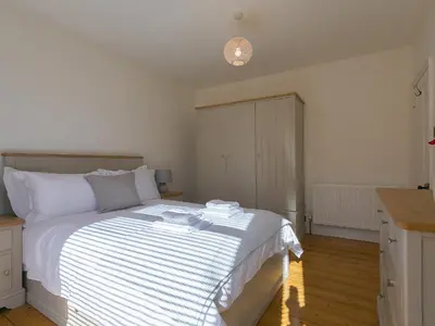 a bedroom with a bed with white sheets and a counter at Trengoff in St Ives