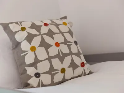 a pillow with white flowers on a bed at Trengoff in St Ives