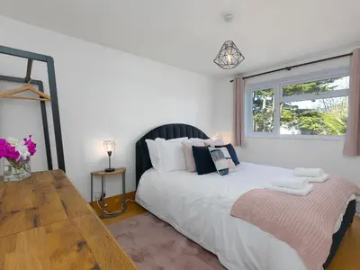 a bedroom with a large white bed with a window at Trengoff in St Ives