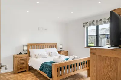 a bedroom with a bed with a television and a desk at Cedar House in St. Agnes