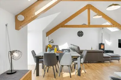 a dining room and living room with a table and chairs at Cedar House in St. Agnes