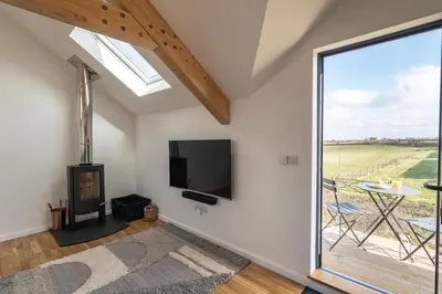 a living room with a flat screen tv and a window at Cedar House in St. Agnes