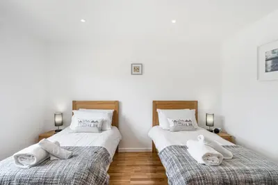 two beds with towels on them in a bedroom at Cedar House in St. Agnes