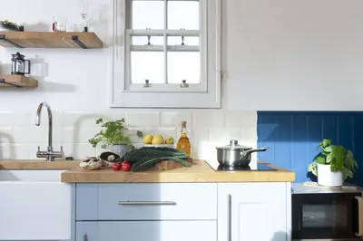 a kitchen with white cabinets and a sink at Nori's Nest, Croft Hooper - Hot Tub - Free WiFi & Parking - Fire Pit in Ludgvan