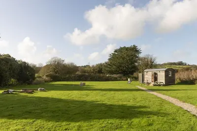 a small shed in a field with a path at Nori's Nest, Croft Hooper - Hot Tub - Free WiFi & Parking - Fire Pit in Ludgvan
