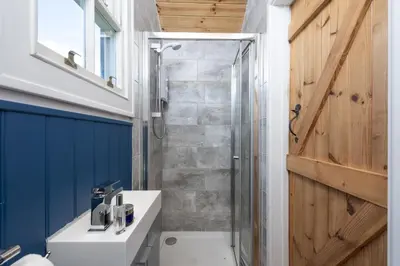a bathroom with a shower and a toilet and a sink at Nori's Nest, Croft Hooper - Hot Tub - Free WiFi & Parking - Fire Pit in Ludgvan