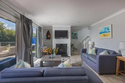 a living room with two blue couches and a table at Lodge 27 - Resort & Spa - Parking - Private Hot Tub in Saint Columb Major