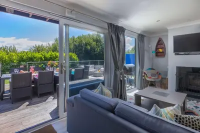a living room with a couch and a sliding glass door at Lodge 27 - Resort & Spa - Parking - Private Hot Tub in Saint Columb Major