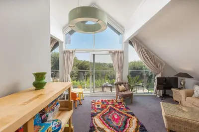 an attic living room with a large window at Lodge 27 - Resort & Spa - Parking - Private Hot Tub in Saint Columb Major