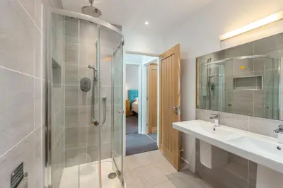 a bathroom with a glass shower and a sink at Lodge 27 - Resort & Spa - Parking - Private Hot Tub in Saint Columb Major