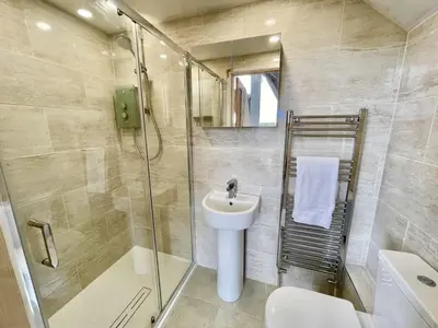 a bathroom with a shower and a sink and a toilet at Lodge 27 - Resort & Spa - Parking - Private Hot Tub in Saint Columb Major