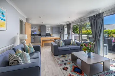 a living room with two blue couches and a table at Lodge 27 - Resort & Spa - Parking - Private Hot Tub in Saint Columb Major