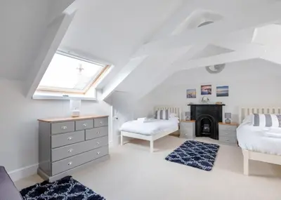 a attic bedroom with two beds and a window at The Terrace 2 in Padstow
