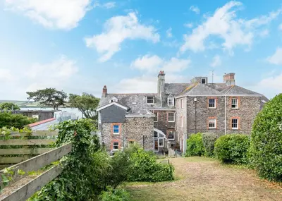 an old stone house with a fence in front of it at The Terrace 2 in Padstow